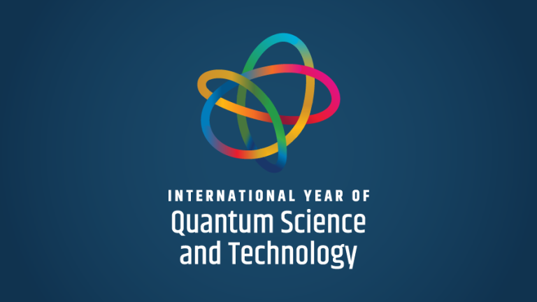 A line that changes color from yellow to red to blue to orange to pink and to green forms a knot on a blue background. Underneath the knot white text says “International Year of Quantum Science and Technology.”